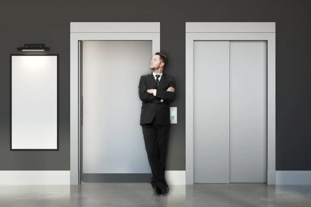 Thoughtful businessman with elevators and banner
