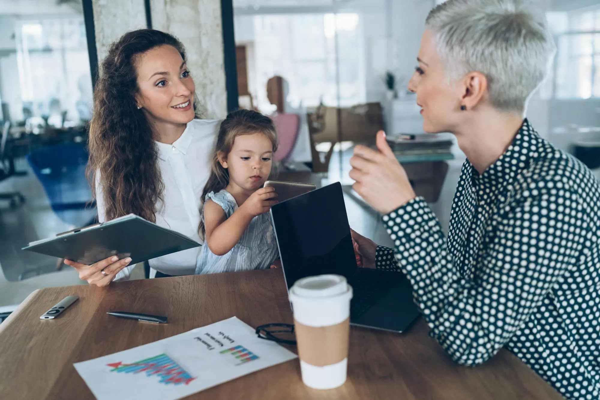 Smiling group of diverse businesspeople working together around a meeting table in an office complex lobby