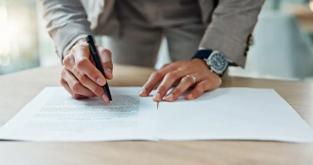 Hands signing a business contract document